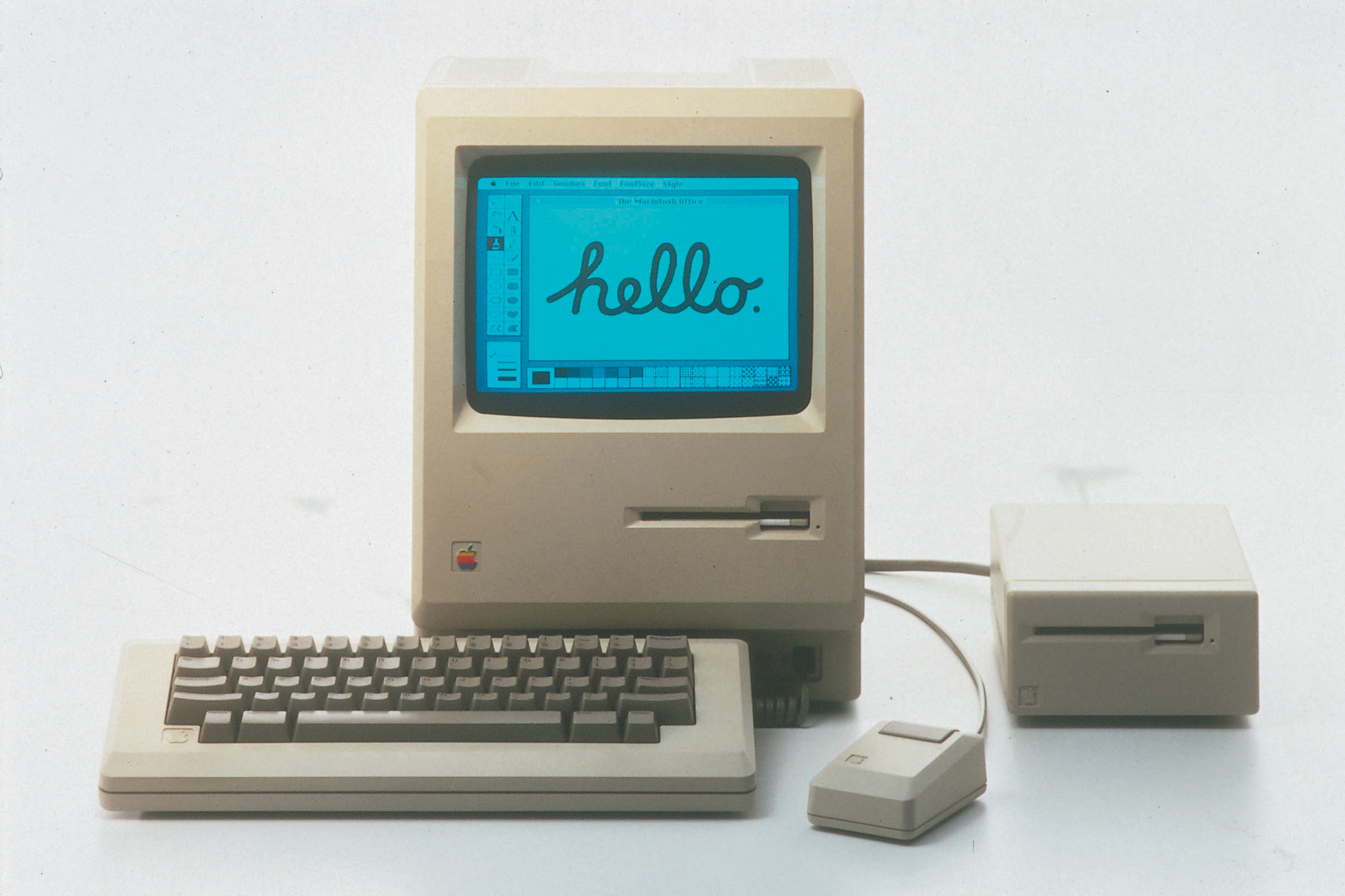 Apple Macintosh z roku 1984 položený s príslušenstvom na stole