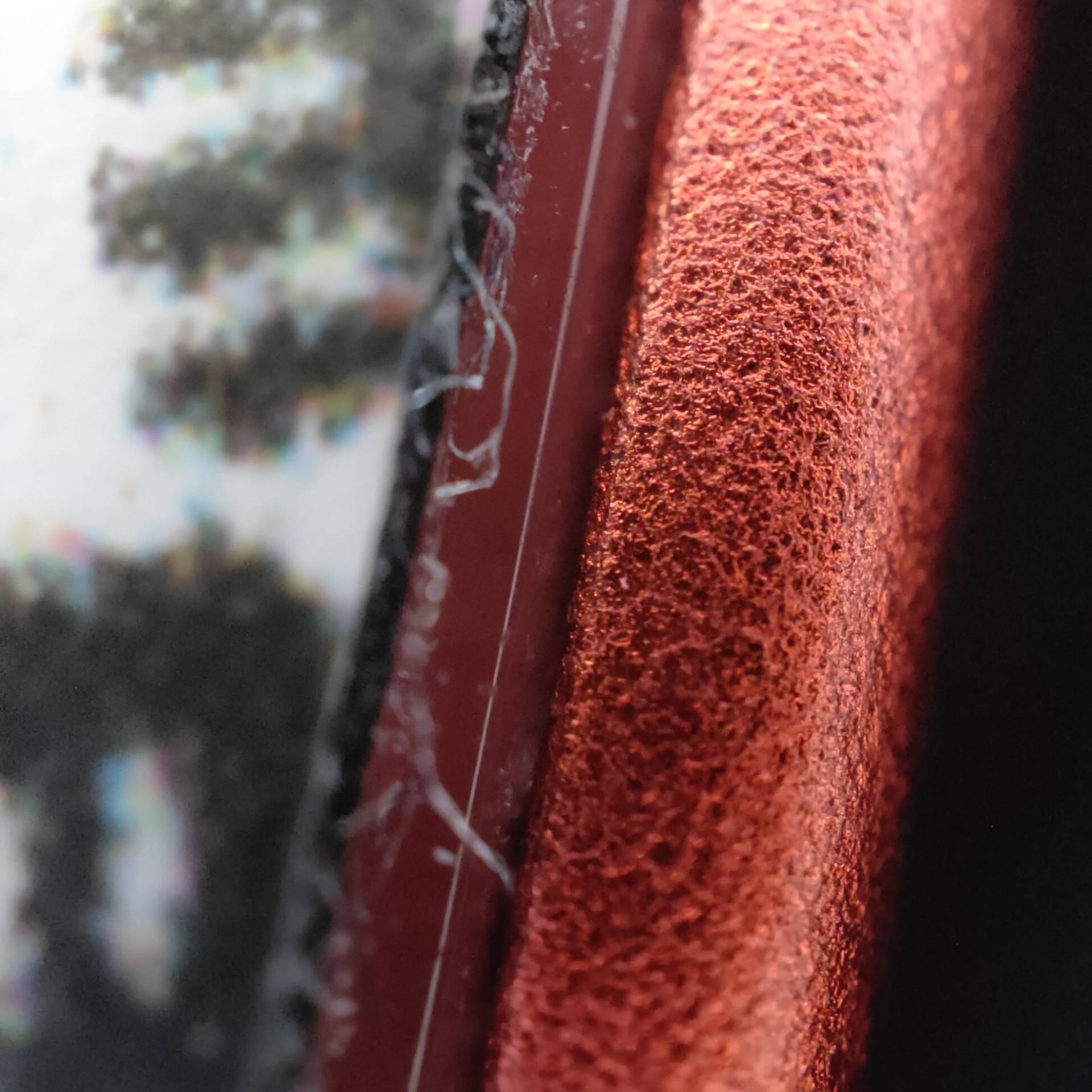 hliník na iPhone 12 pod mikroskopom
