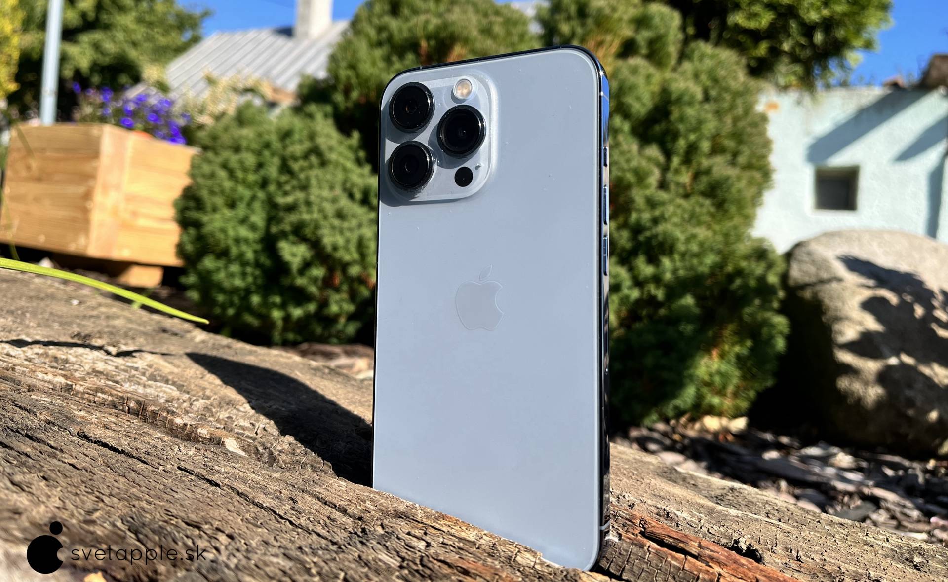 iPhone 13 Pro vo farbe Sierra Blue v záhrade - záber na výšku zo zadnej strany