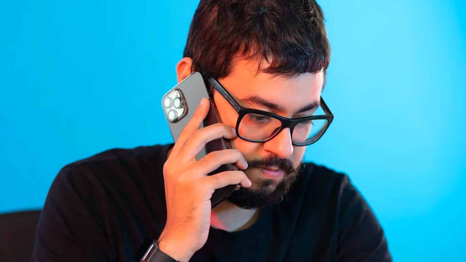 Muž v okuliaroch držiaci iPhone 12
