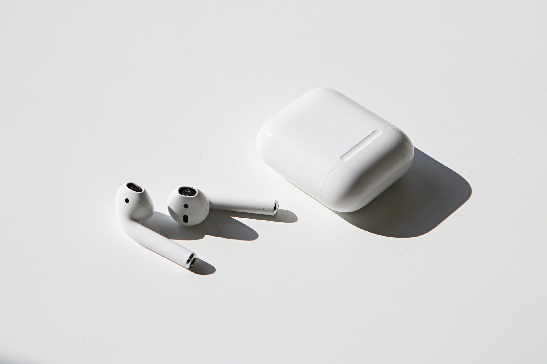 AirPods 2. generácie vytiahnute z nabijacieho puzdra položene na bielom stole