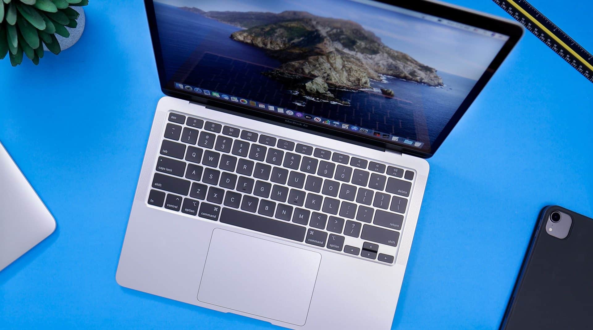 MacBook Air sivý z roku 2022 M1 položený na modrom stole