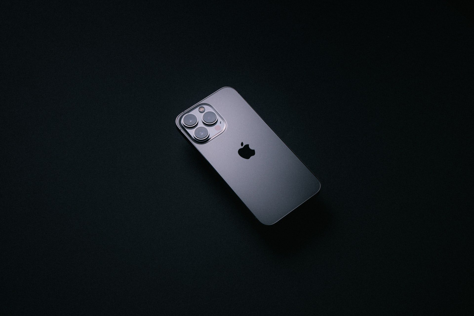 iPhone 13 Pro v sivej farbe graphite na čiernom pozadí zo zadnej strany