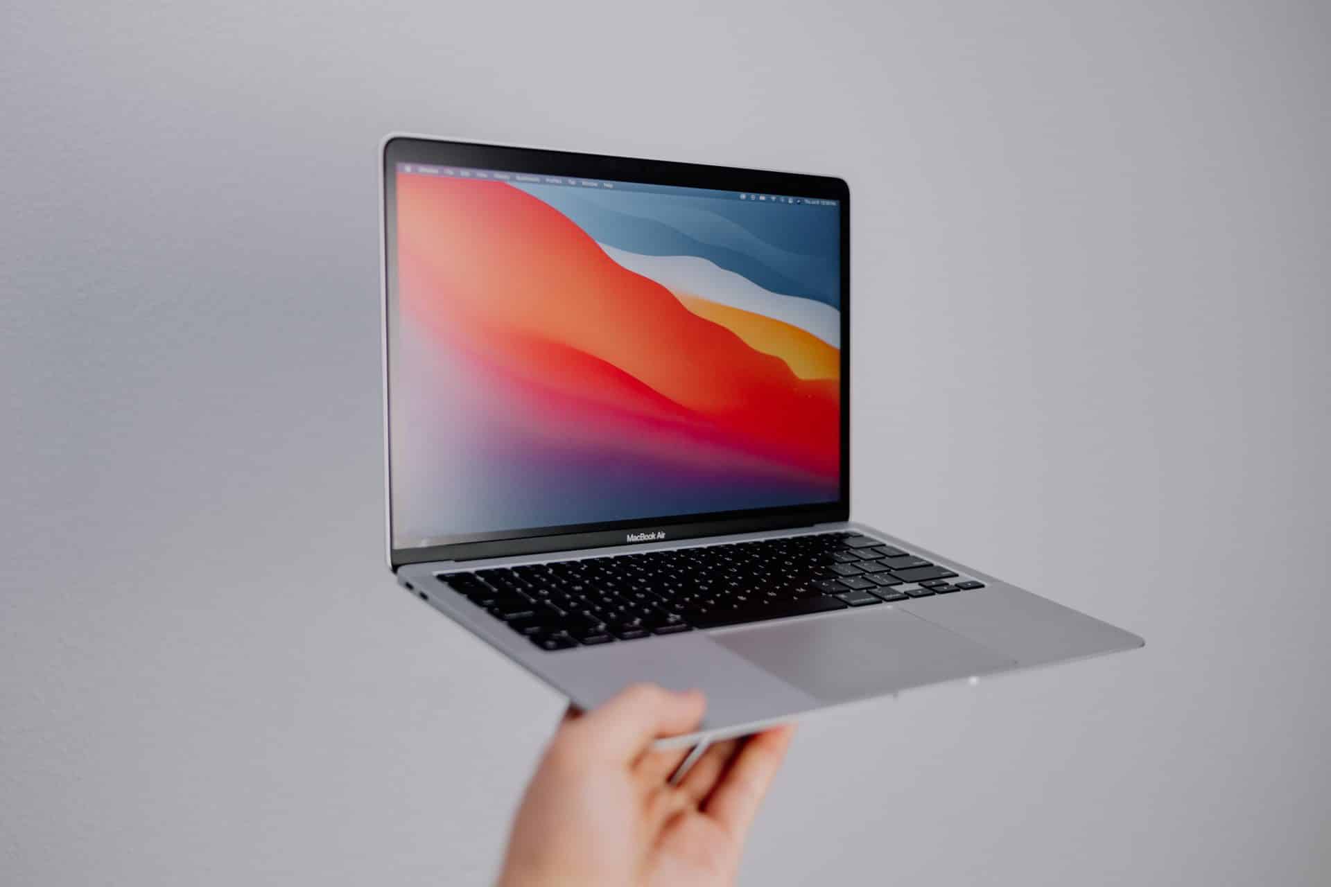 MacBook Air v striebornej farbe v ruke používateľa