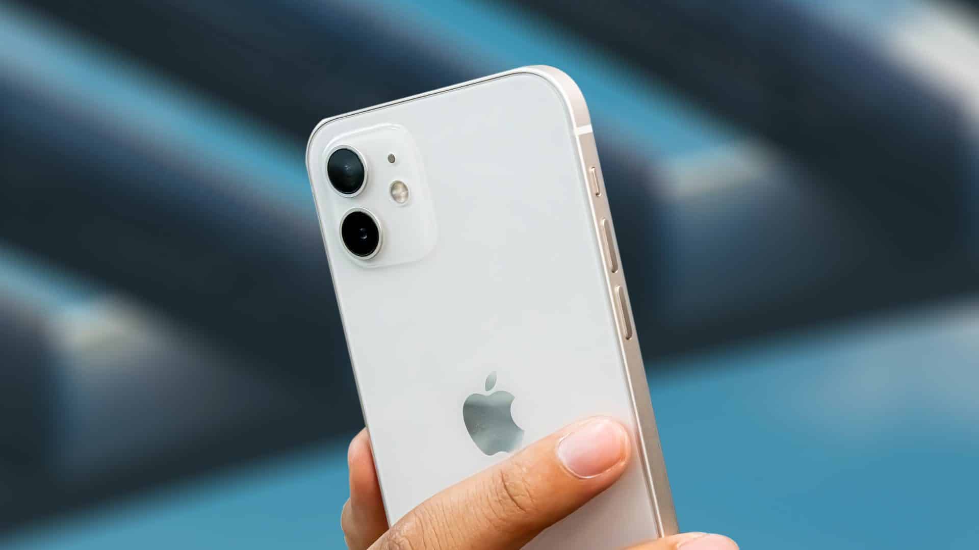 iPhone 12 v bielej farbe, nachádzajúci sa v ruke používateľa