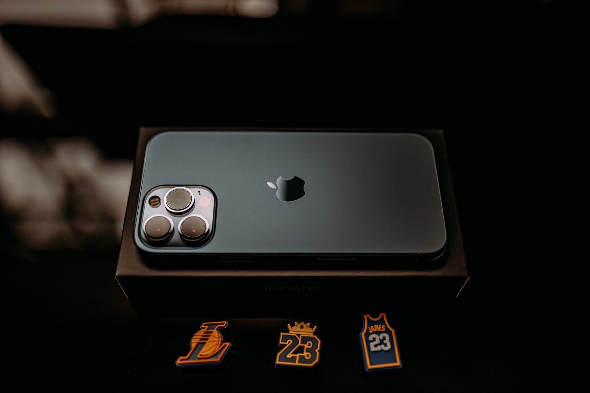 iPhone 13 Pro vo svetlo sivej farbe graphite zo zadnej strany na stole