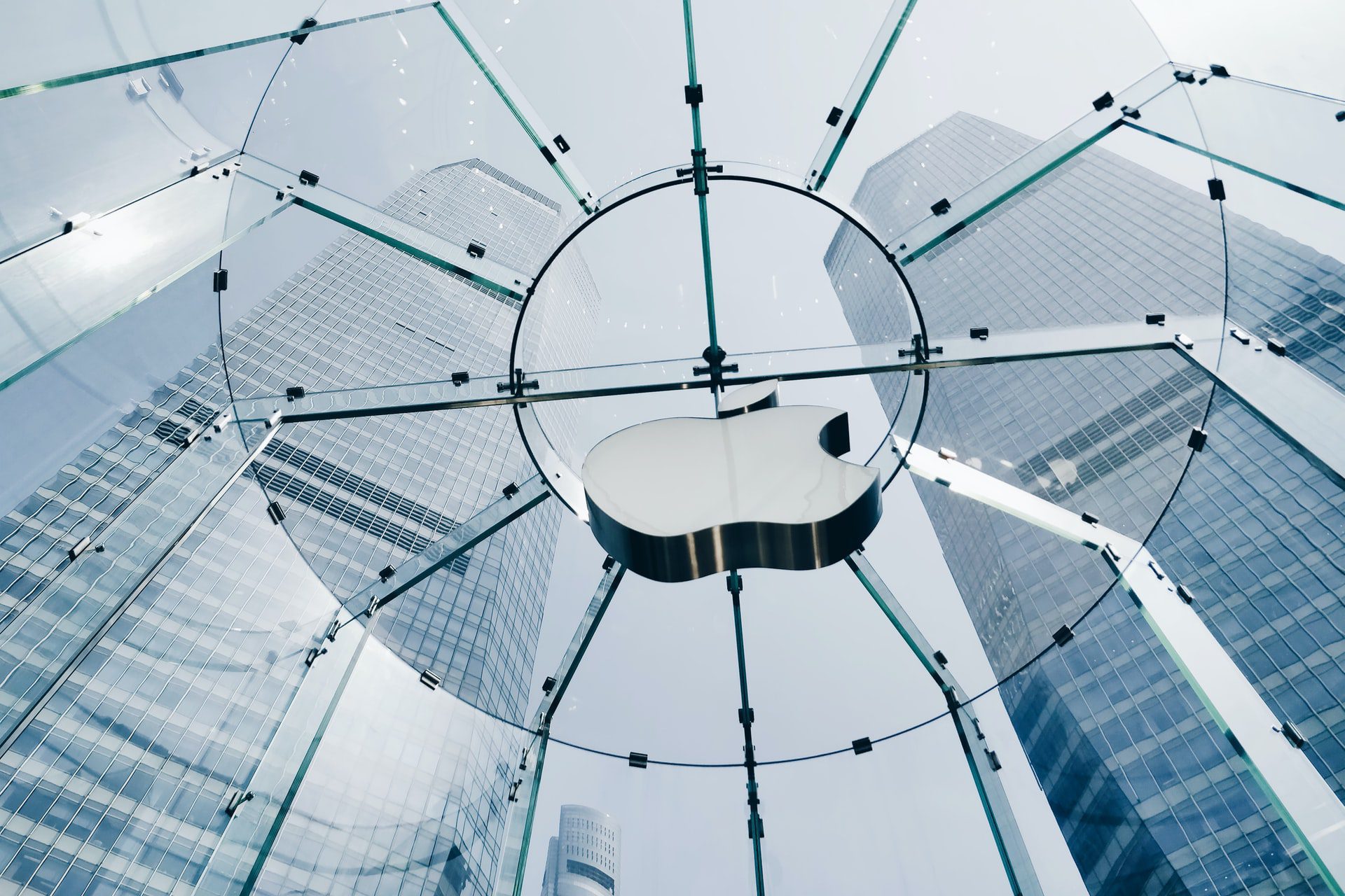 Apple logo v sklenenom Apple Store a mrakodrapy