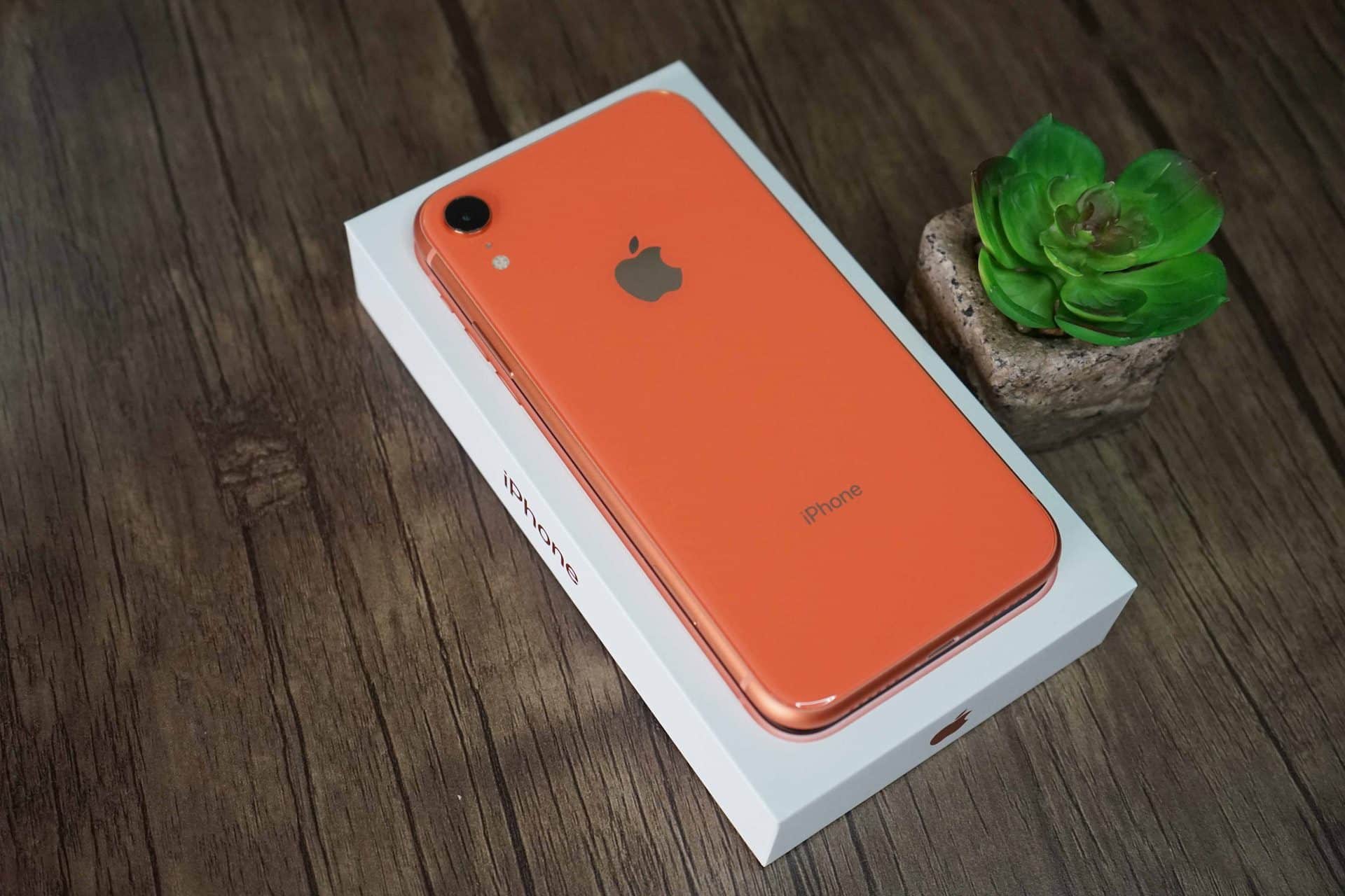 iPhone XR v oranžovej (korálovej) farbe položený na krabičke