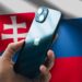Čierny iPhone 13 v ruke a so slovenskou vlajkou v pozadí